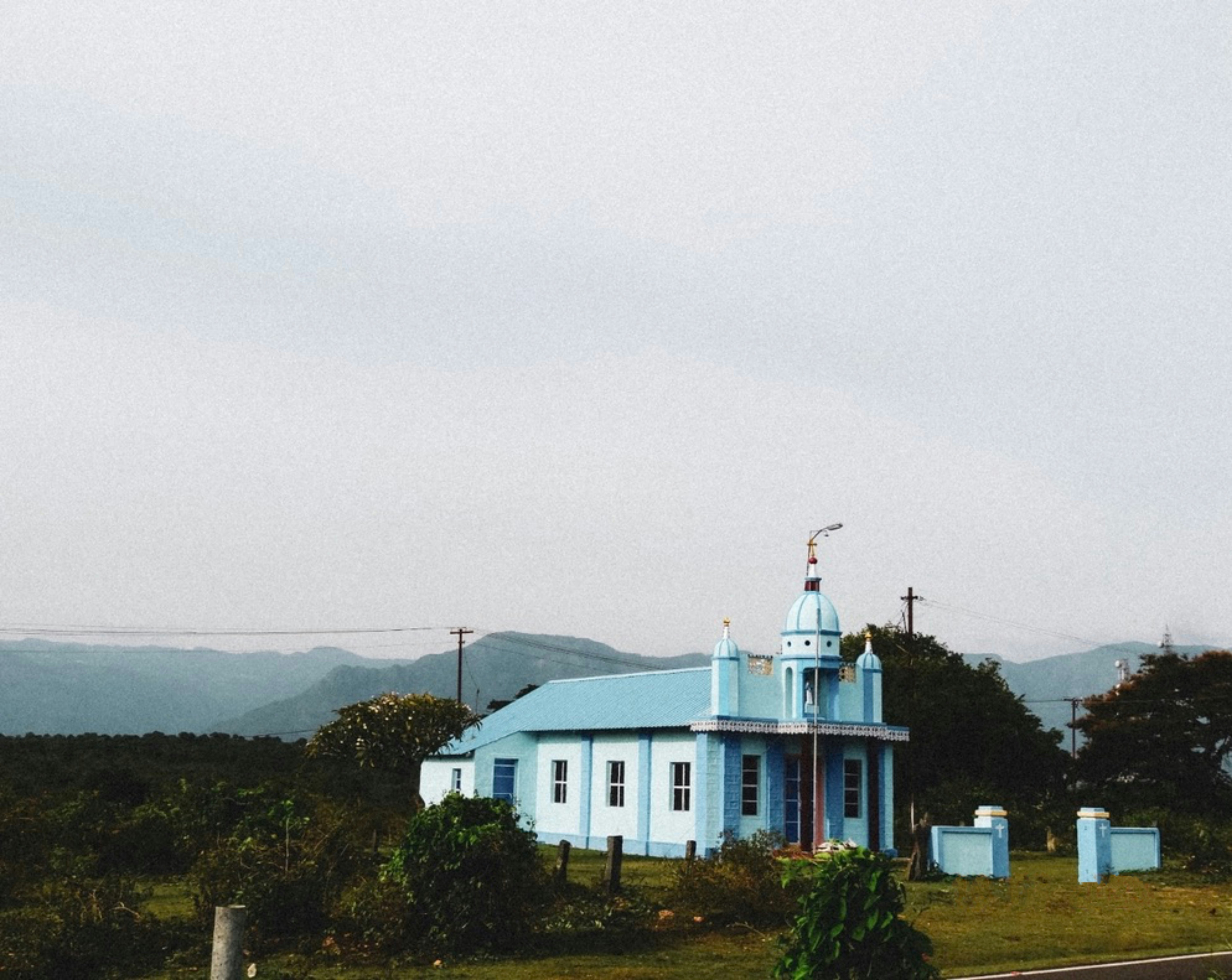 A blue building with a cross on top of it