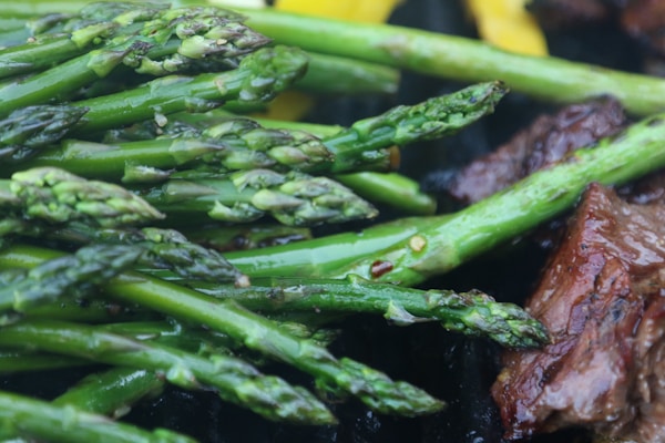 A plate of steak and asparagus on a grill