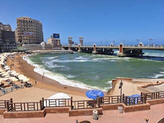 A panoramic view of a beach with a pier in the background