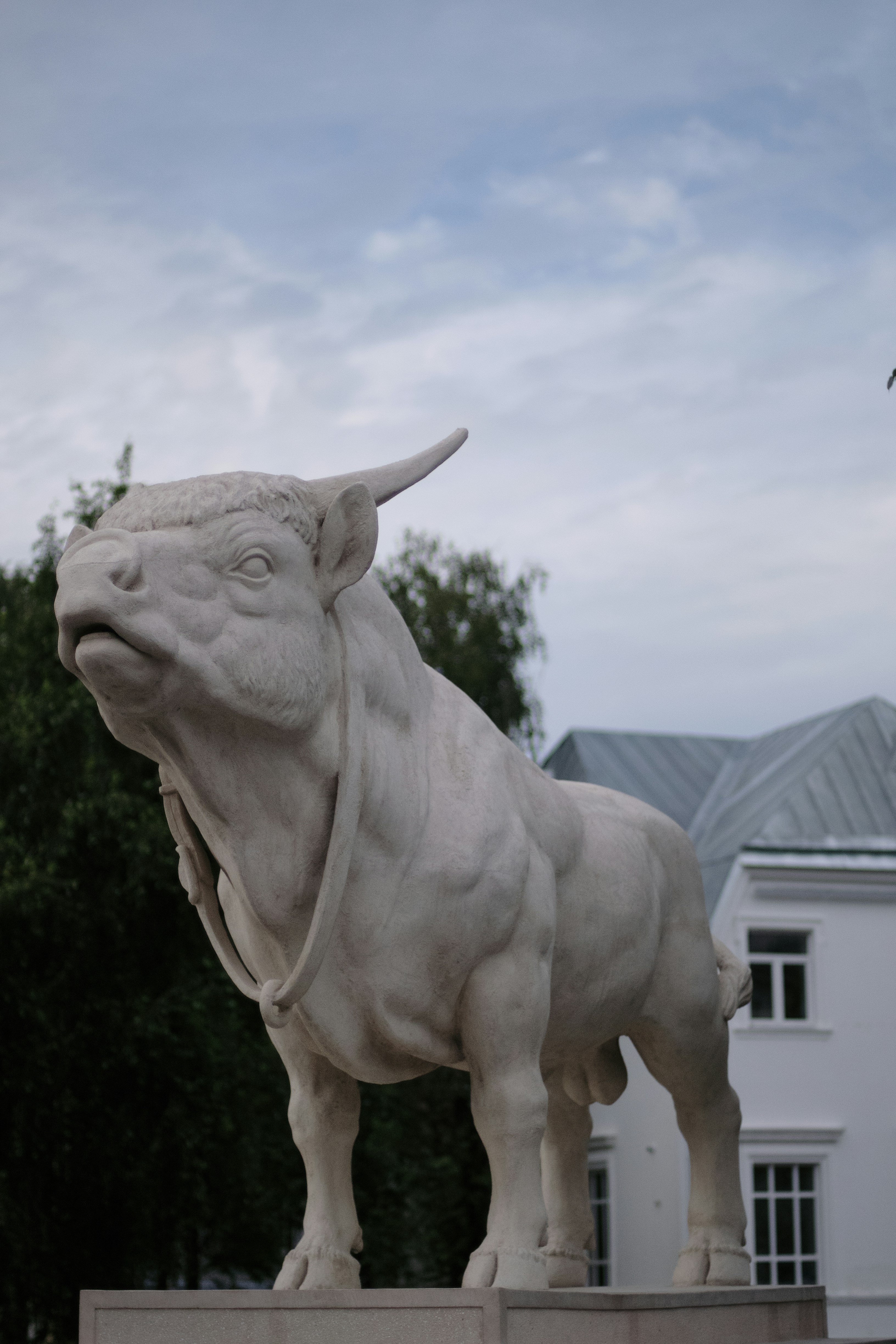 A statue of a bull is in front of a building