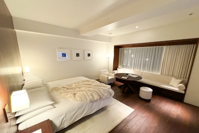 A bedroom with a large bed and wooden floors