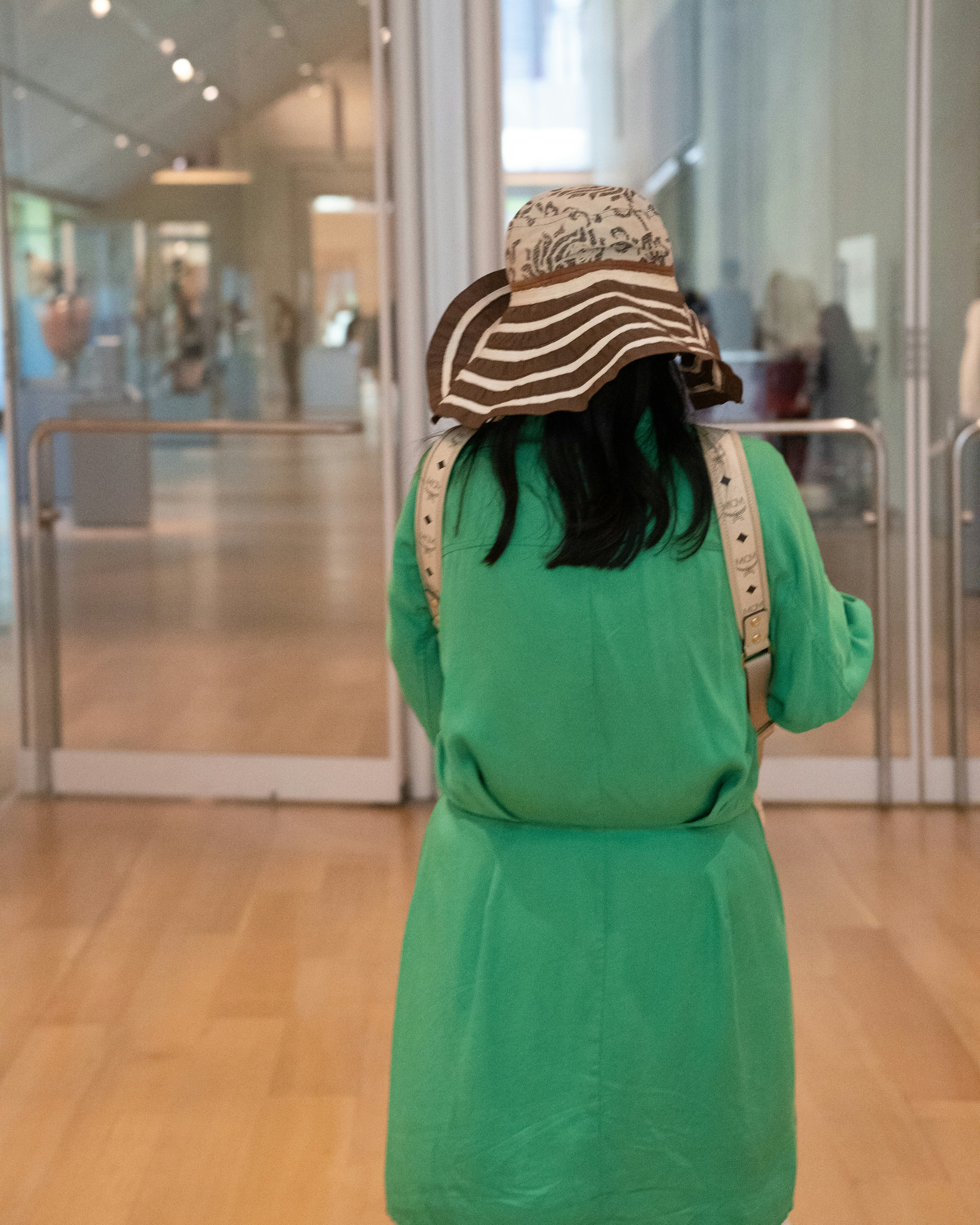 Une femme en robe verte et chapeau noir et blanc