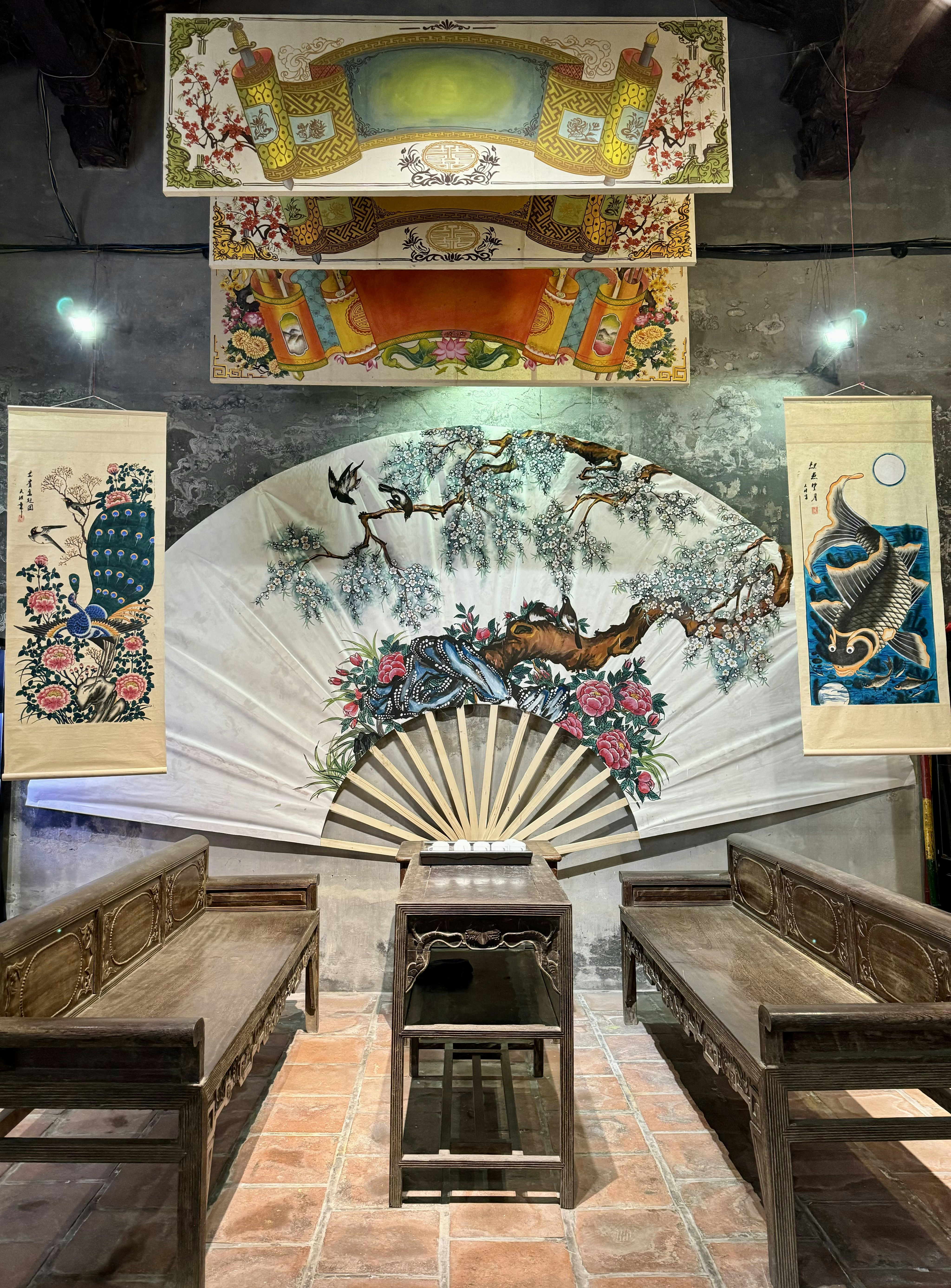 Uma sala cheia de bancos de madeira e um ventilador