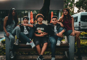 A group of people sitting on top of a wooden bench