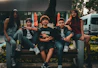 A group of people sitting on top of a wooden bench