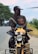 A man riding a motorcycle with a child on the back of it