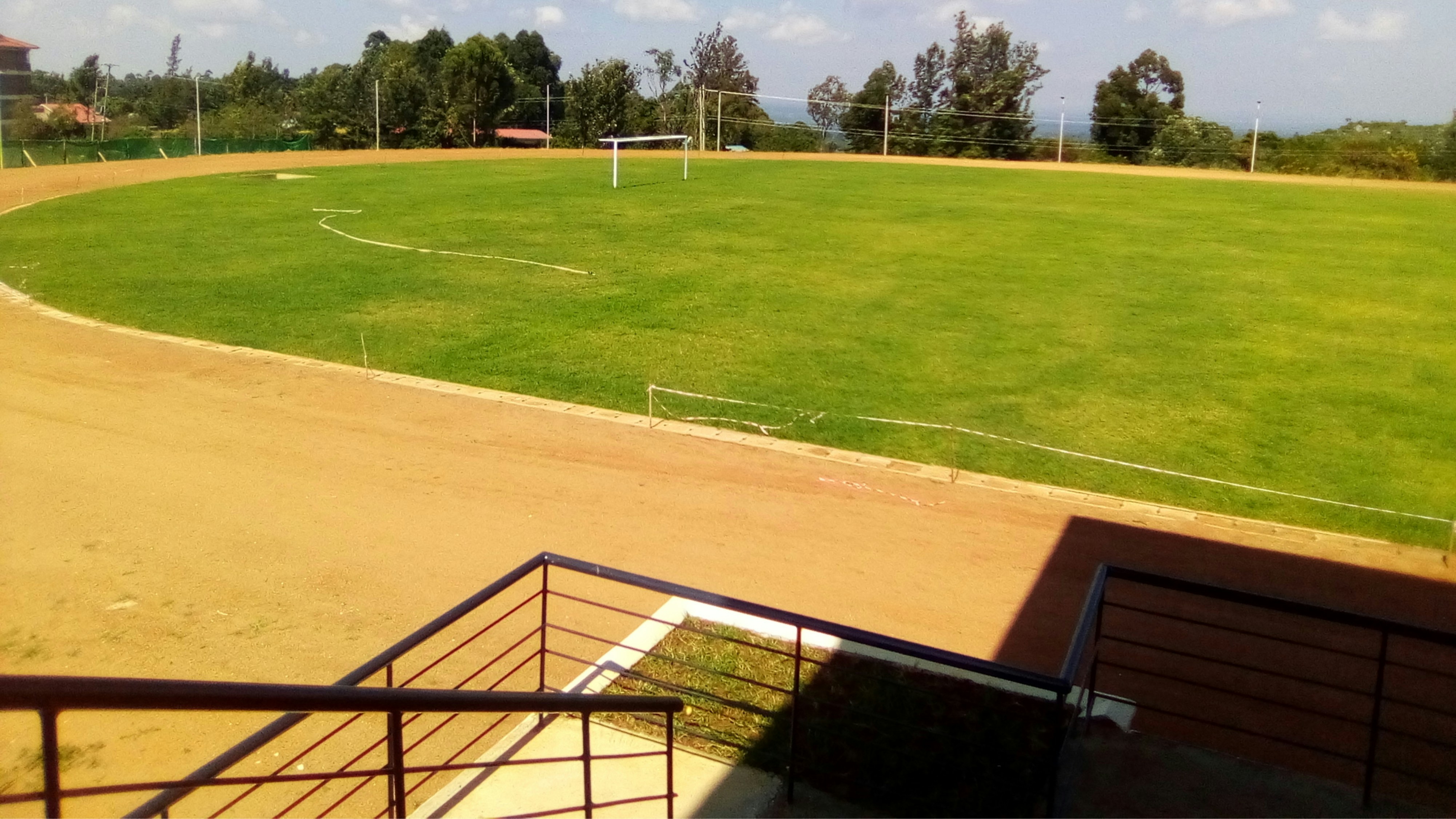 Campo de fútbol con césped natural verde y arcos en día soleado