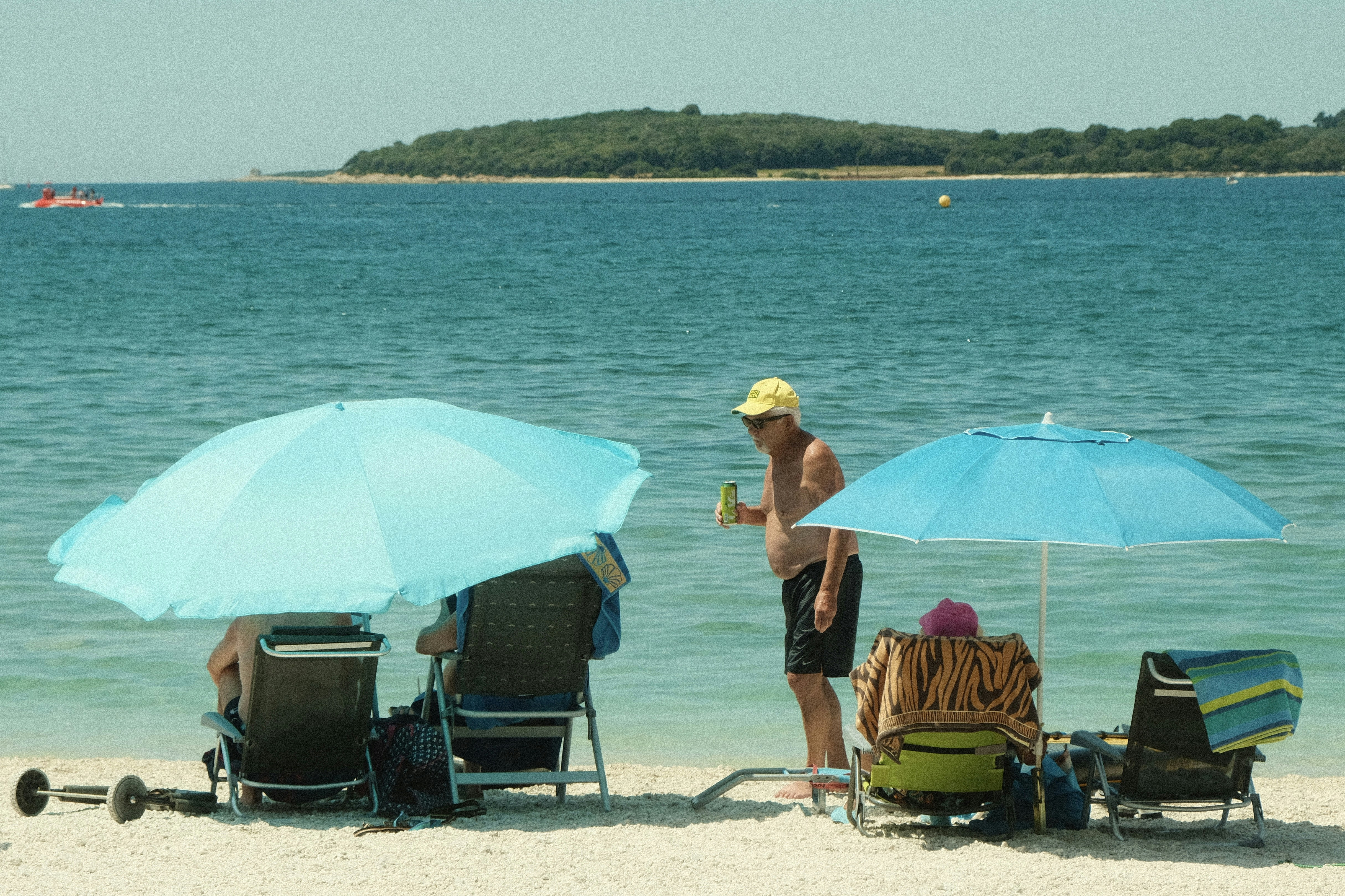 A group of people sitting under umbrellas on a beach