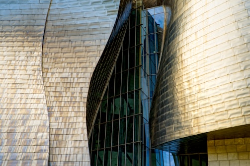 A tall building with a curved roof next to another building