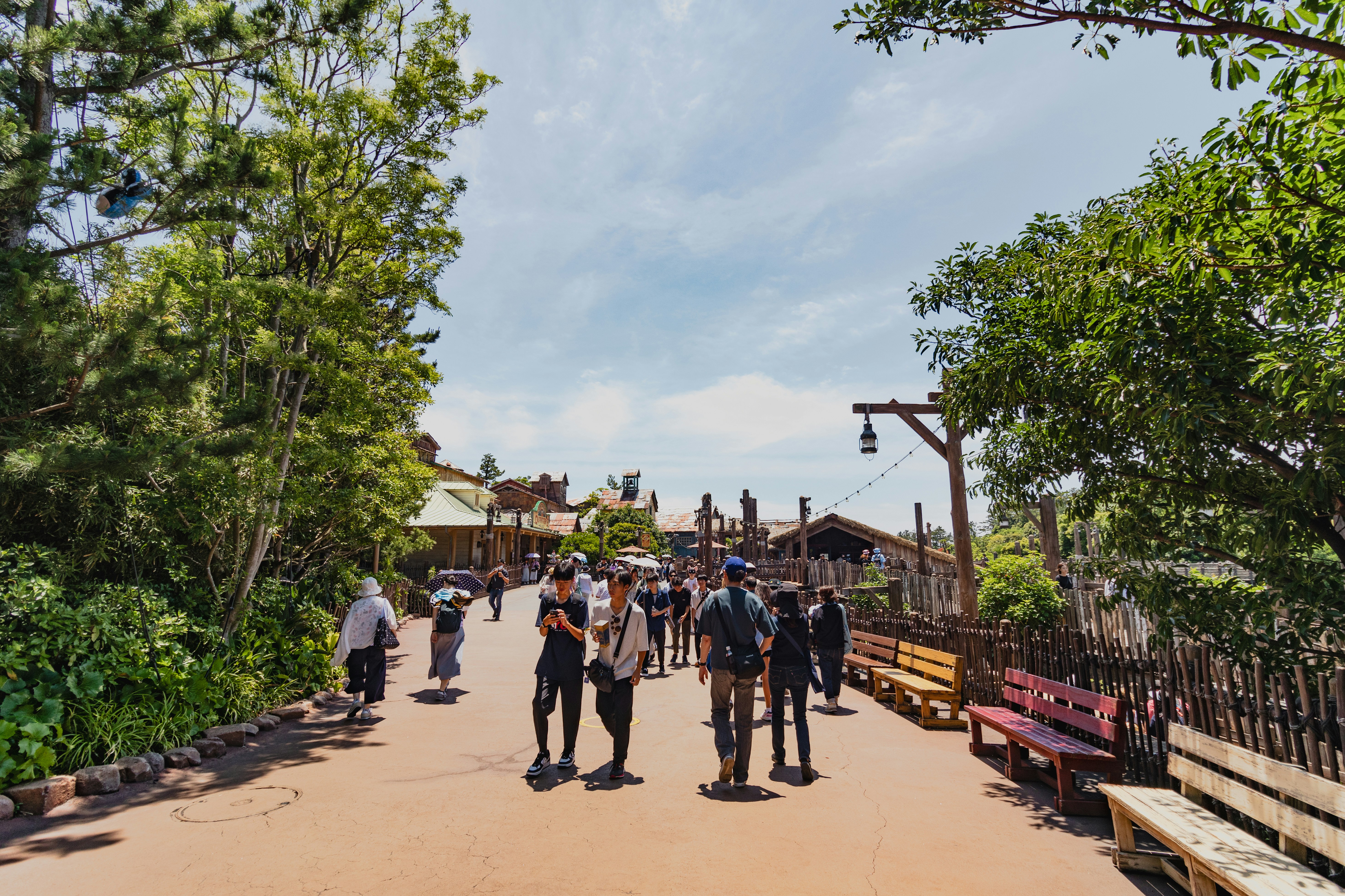A group of people walking down a dirt road, 