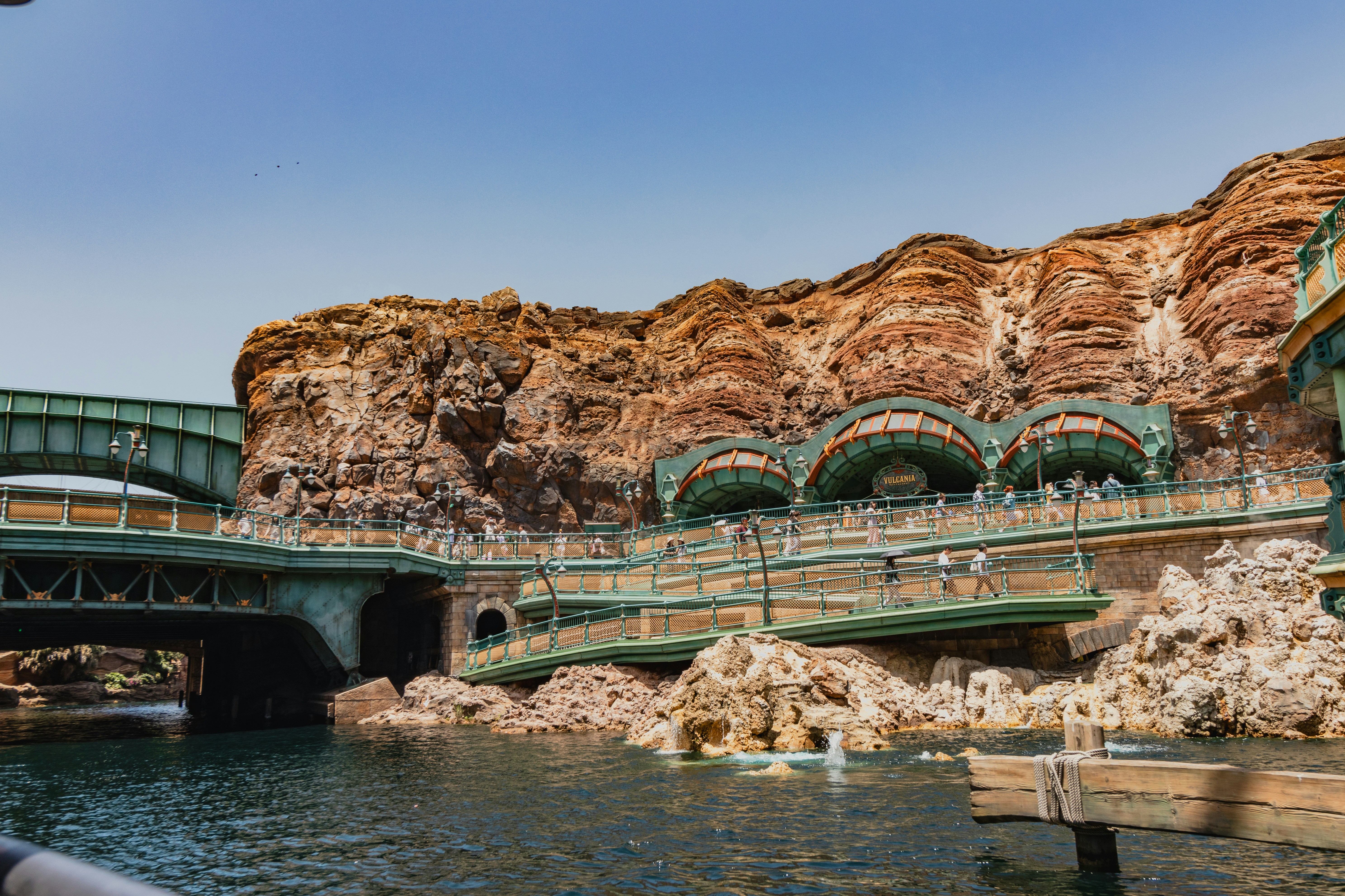 A bridge over a body of water with a mountain in the background