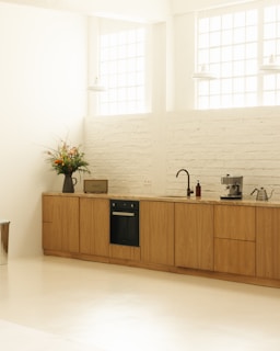A kitchen with a stove, sink, and cabinets