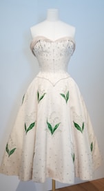 A white dress with green leaves on it