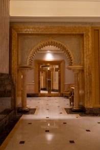 A long hallway with columns and a clock on the wall