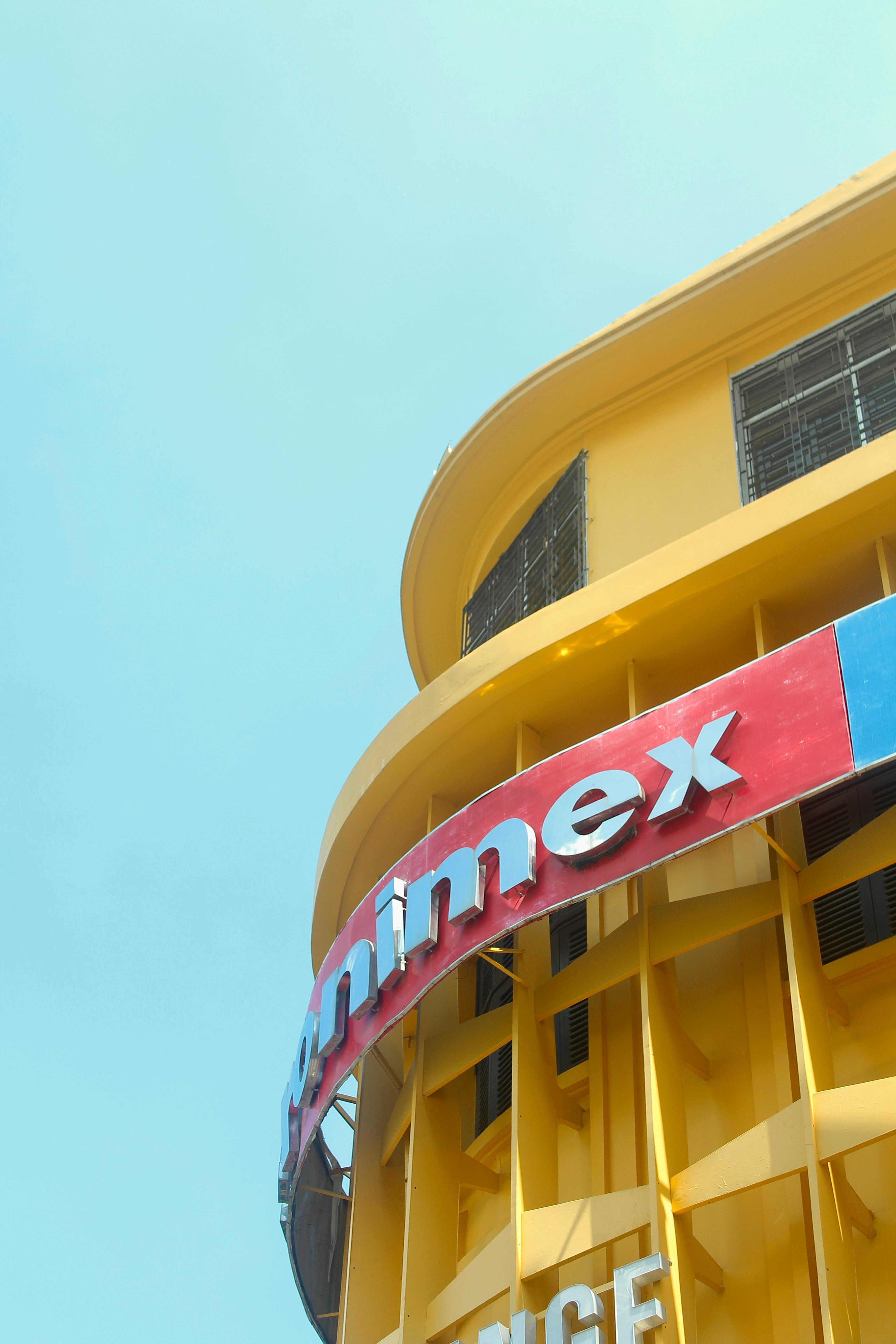 A tall yellow building with a red and blue sign on it's side