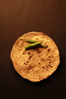 A tortilla with a green pepper on top of it