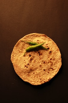 A tortilla with a green pepper on top of it