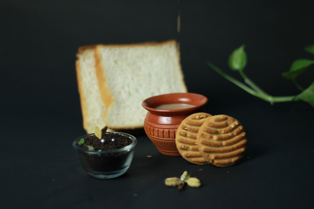 A piece of bread, a bowl of peanut butter and a bowl of peanut butter