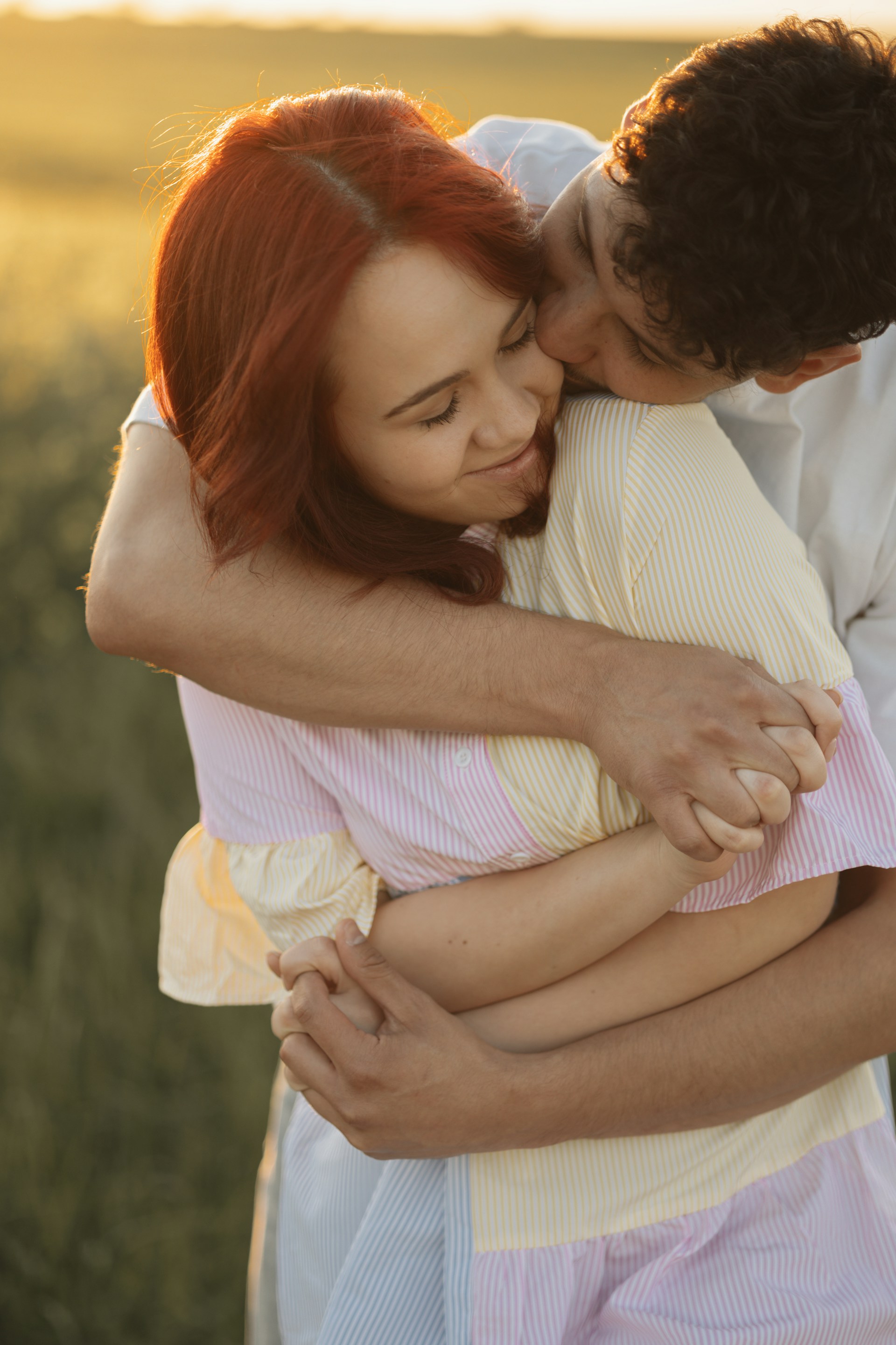 A man and woman embracing each other in a field
