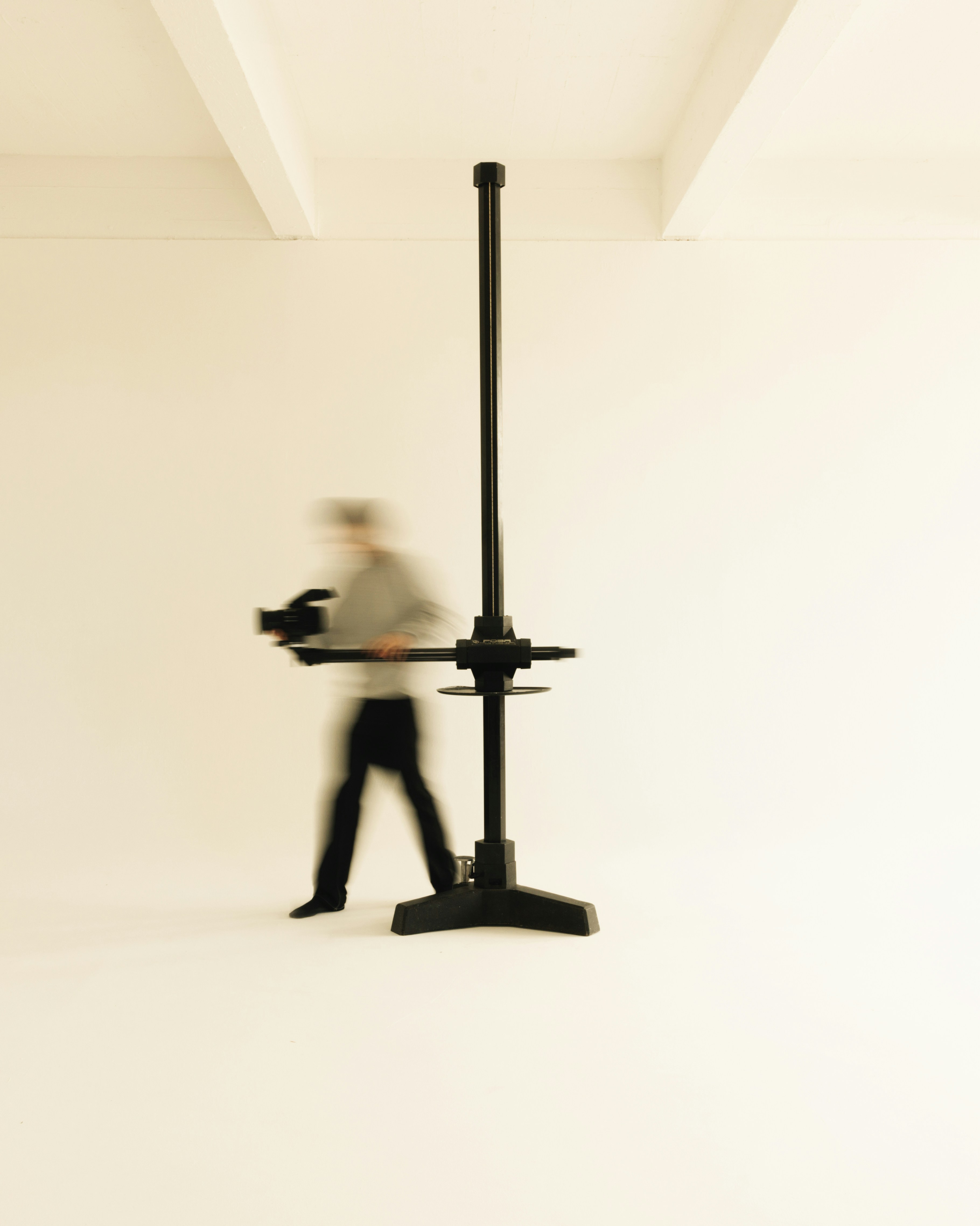 A blurry image of a man walking past a desk
