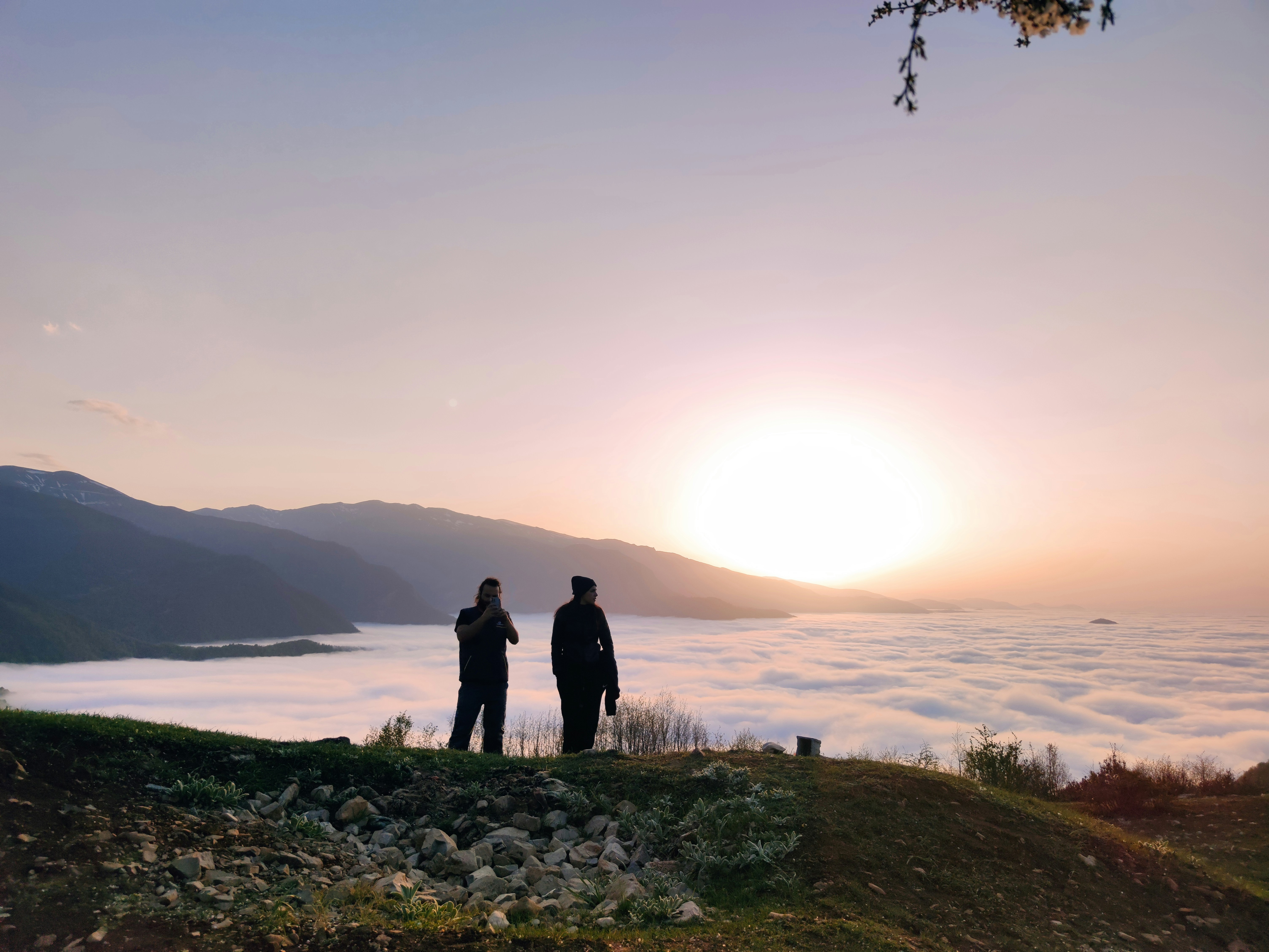 A couple of people standing on top of a hill