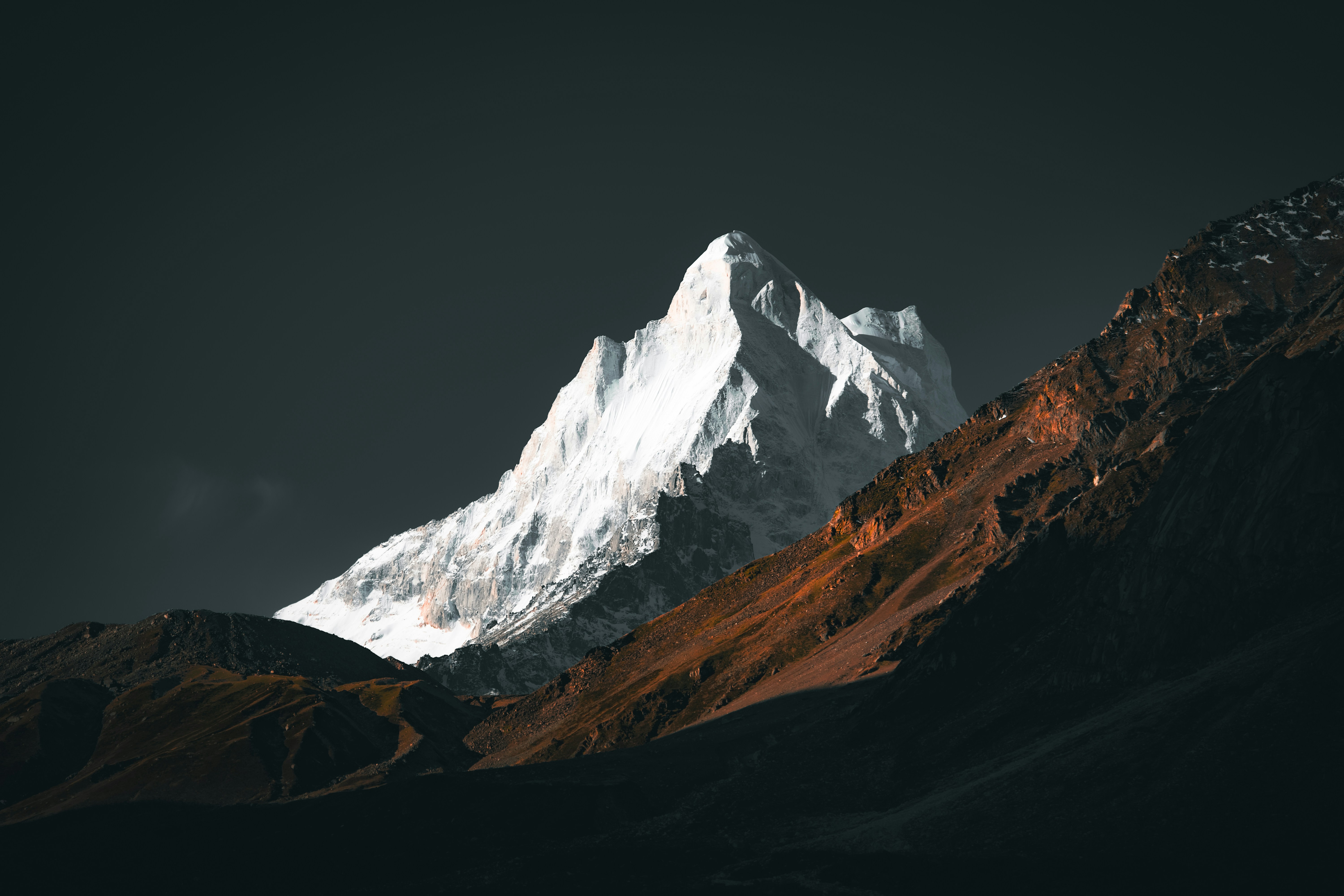 A snow covered mountain with a dark sky in the background photo – Free Wallpaper  Image on Unsplash, image size:3000x2000
