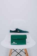 A pair of lacoste shoes sitting on top of a white chair