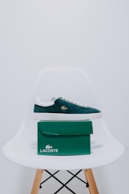 A pair of lacoste shoes sitting on top of a white chair