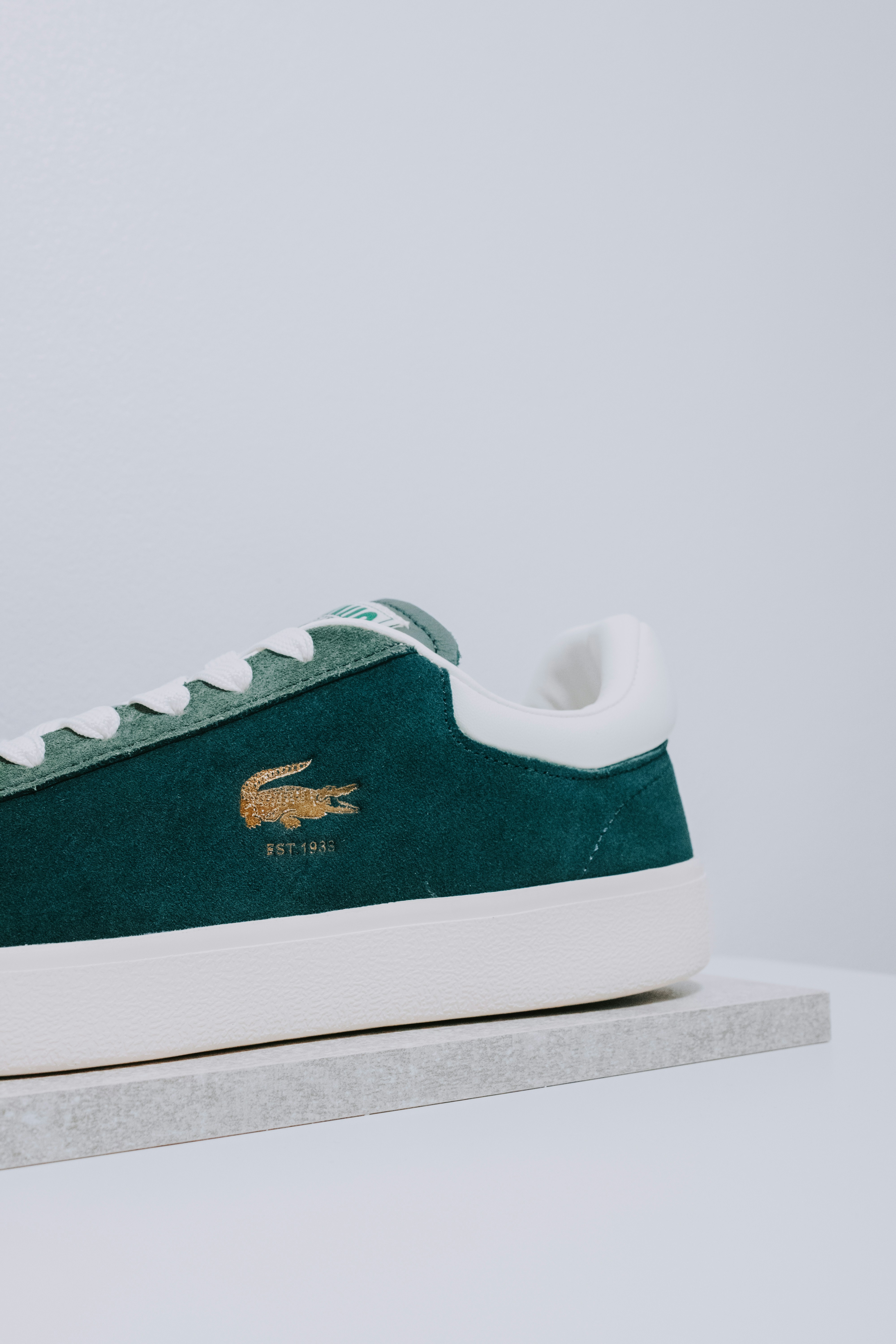 A green and white sneaker with a crocodile on the side