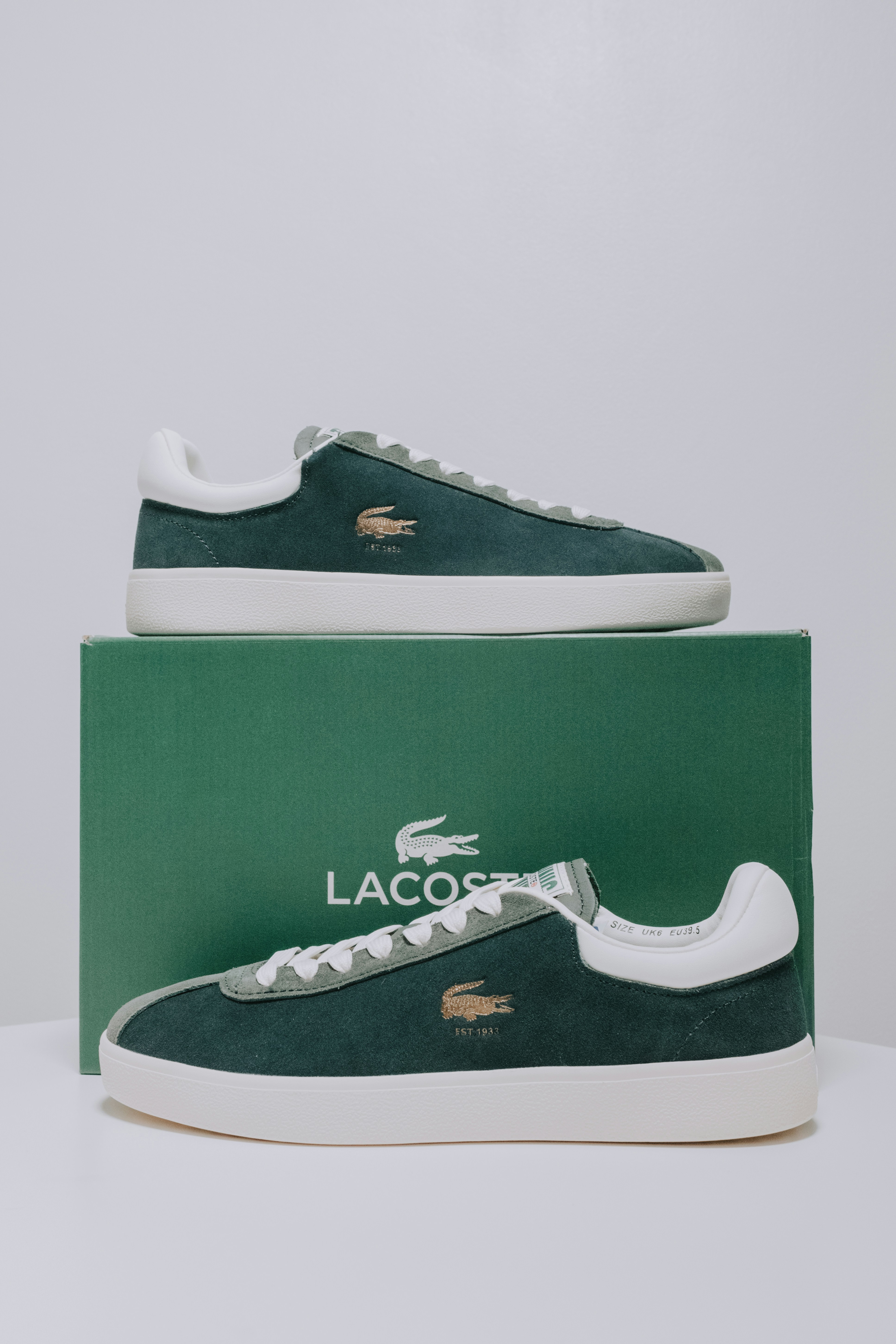 A pair of lacost sneakers in a green box
