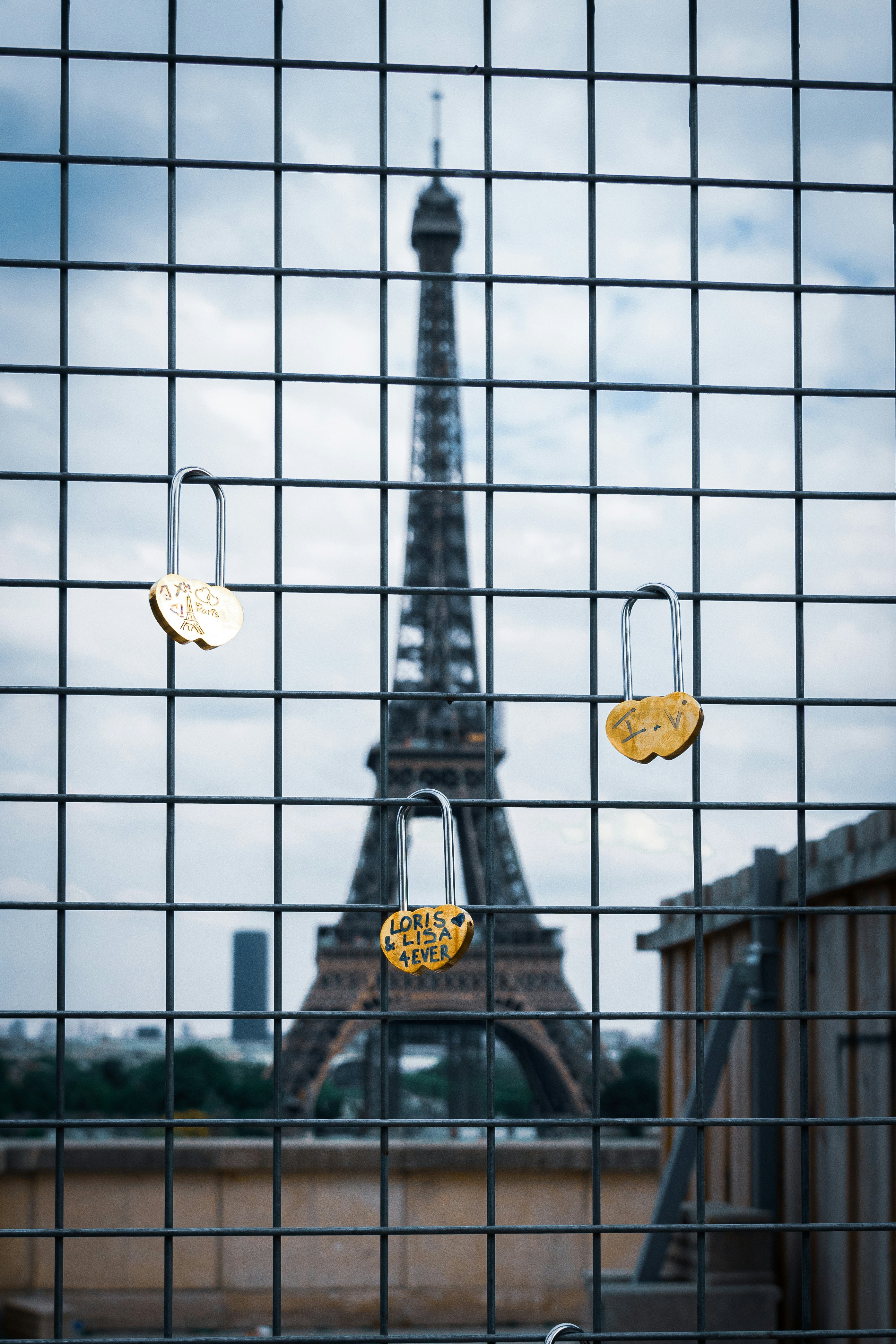 Uma vista da torre eiffel através de uma cerca