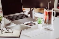 A laptop computer sitting on top of a white desk