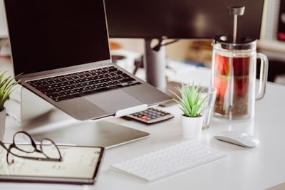 A laptop computer sitting on top of a white desk