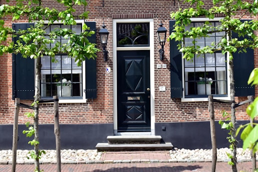 A building with a black door surrounded by trees
