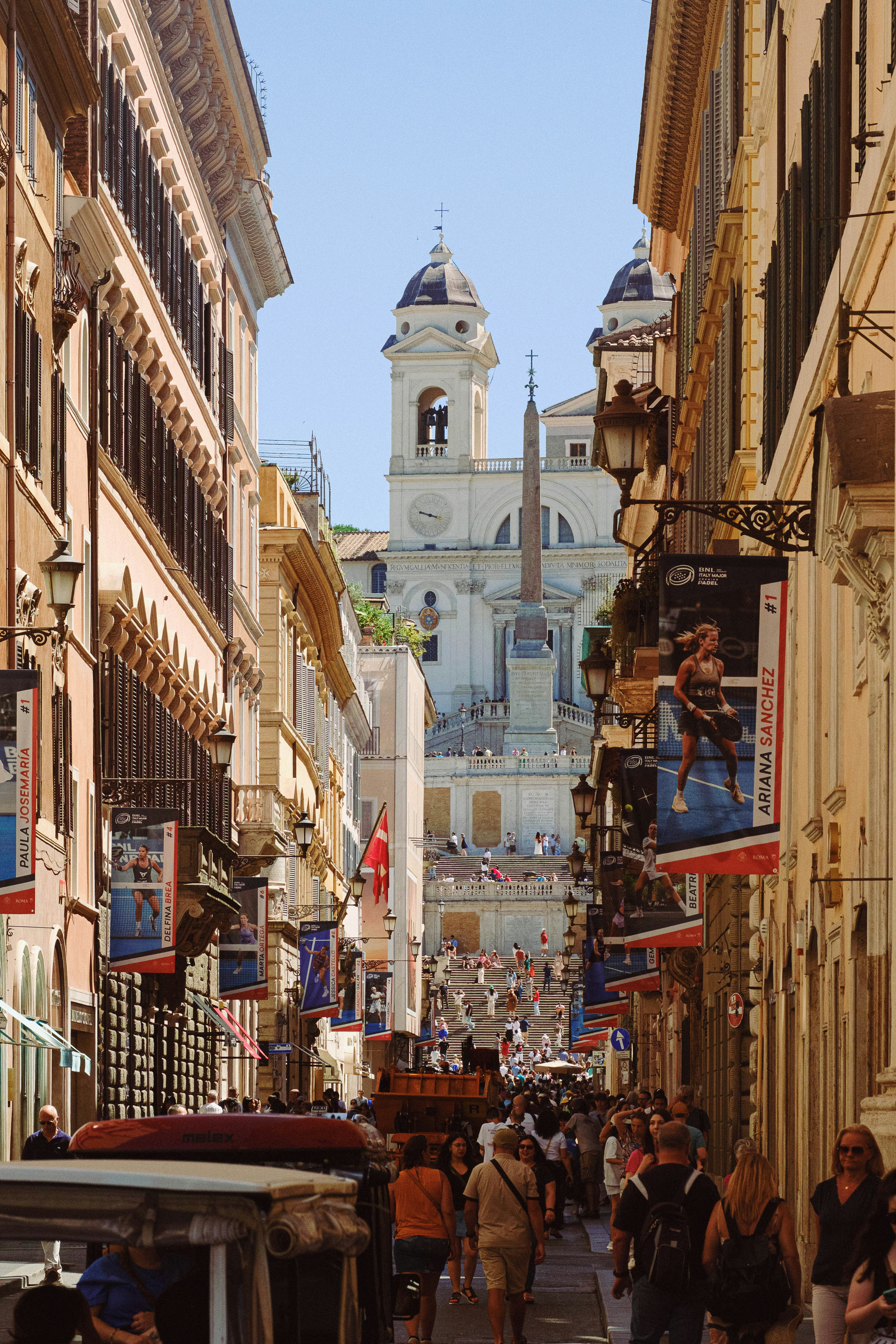 Una calle estrecha de la ciudad con gente caminando por ella