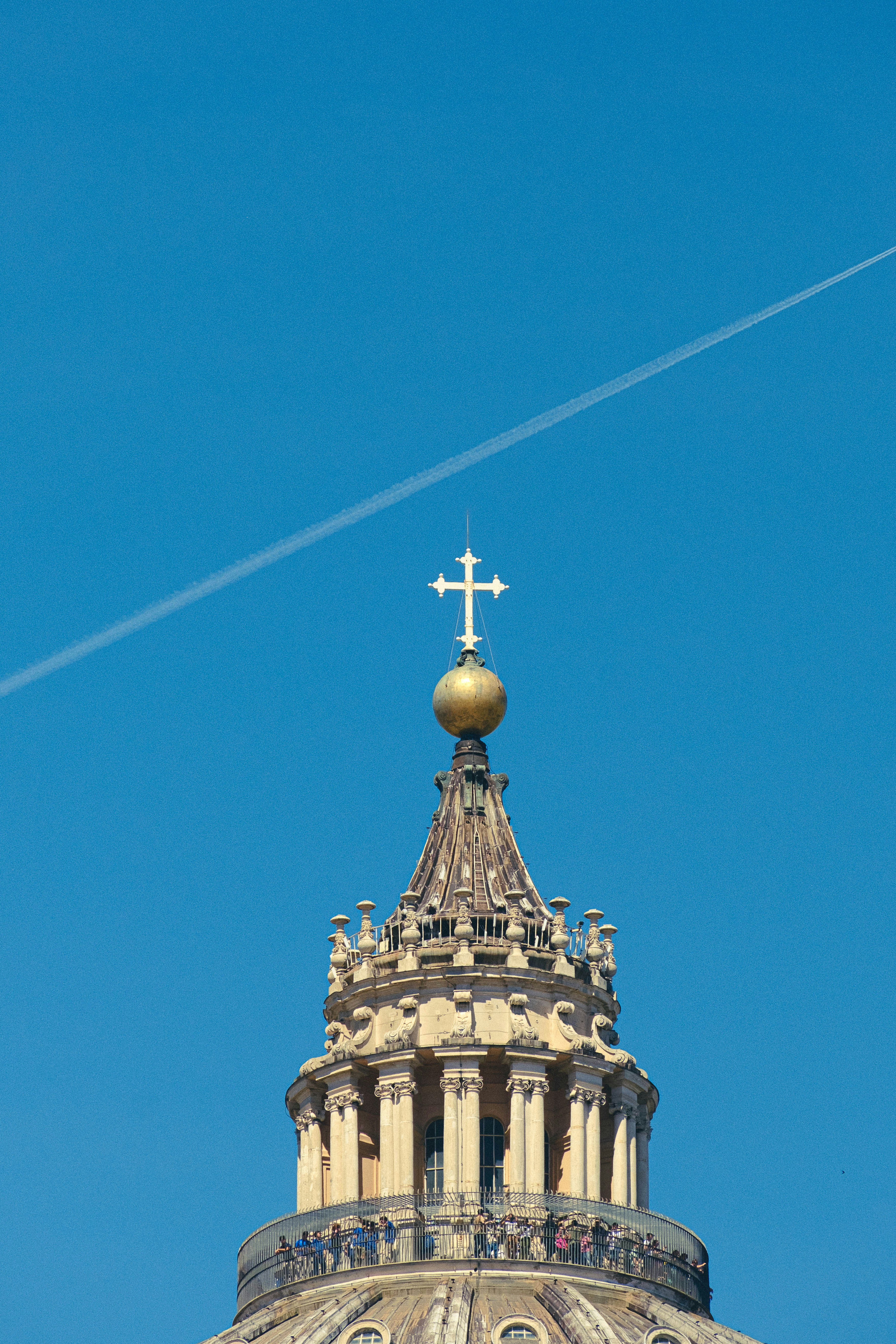 Un avión volando sobre un edificio con una cruz en la parte superior