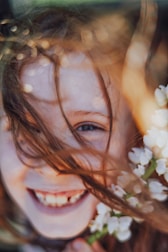 A little girl holding a bunch of white flowers