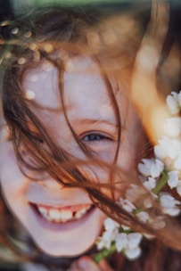 A little girl holding a bunch of white flowers