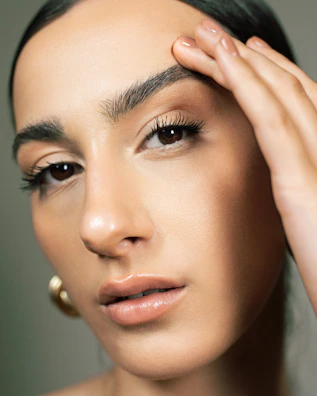 A close up of a woman holding her hand to her face