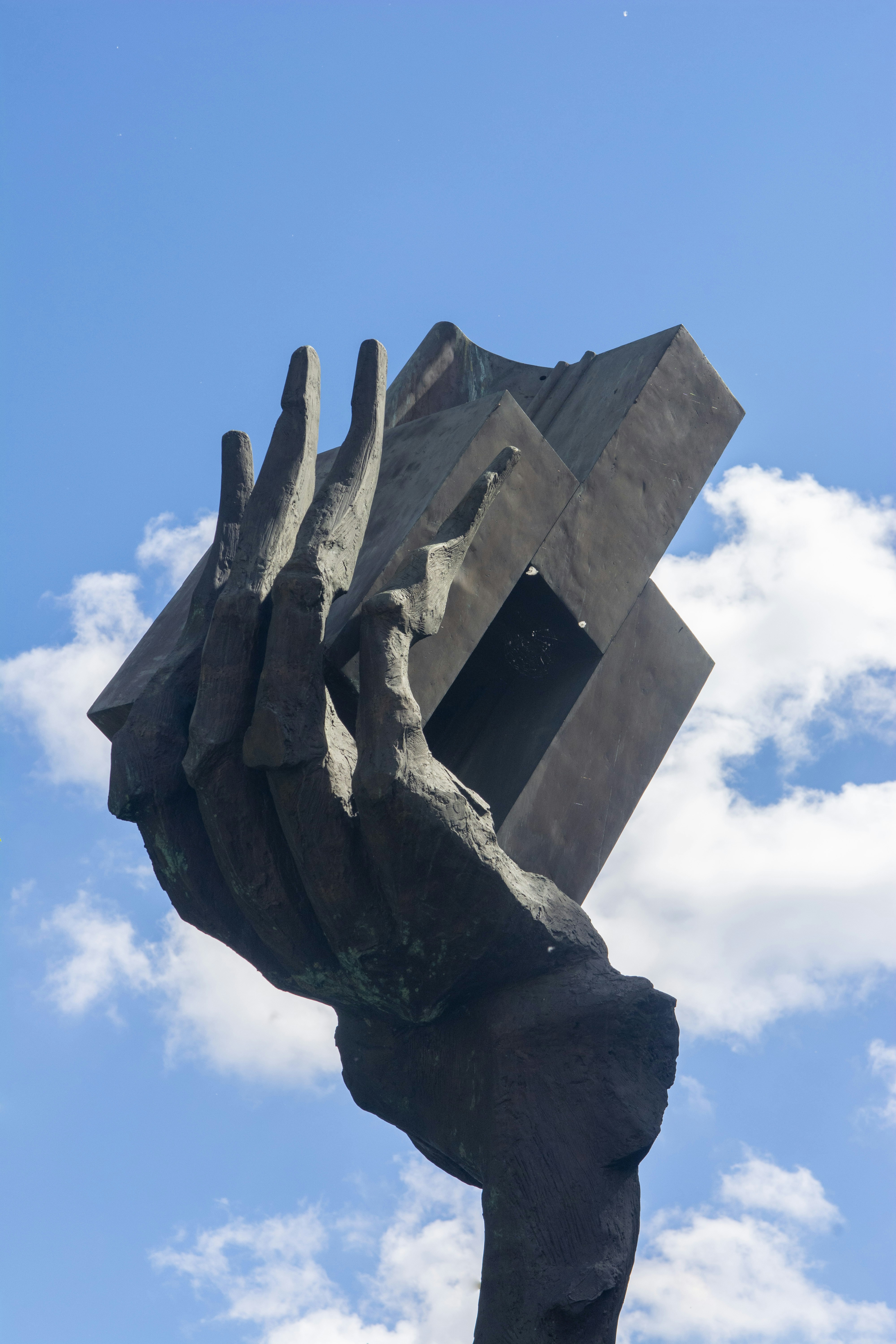 A statue of a hand holding a cube