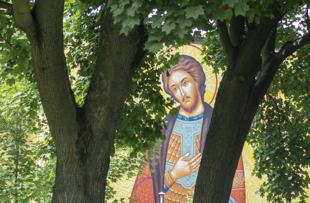 A painting of a woman holding a baby in a park,