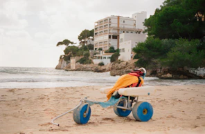 Lightweight beach wheelchair with balloon tires on sandy shore, designed for easy access to the sea.