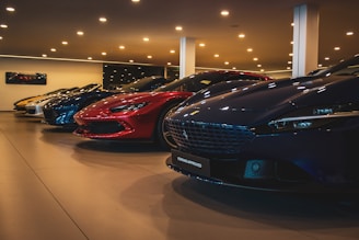 A bunch of cars are parked in a showroom