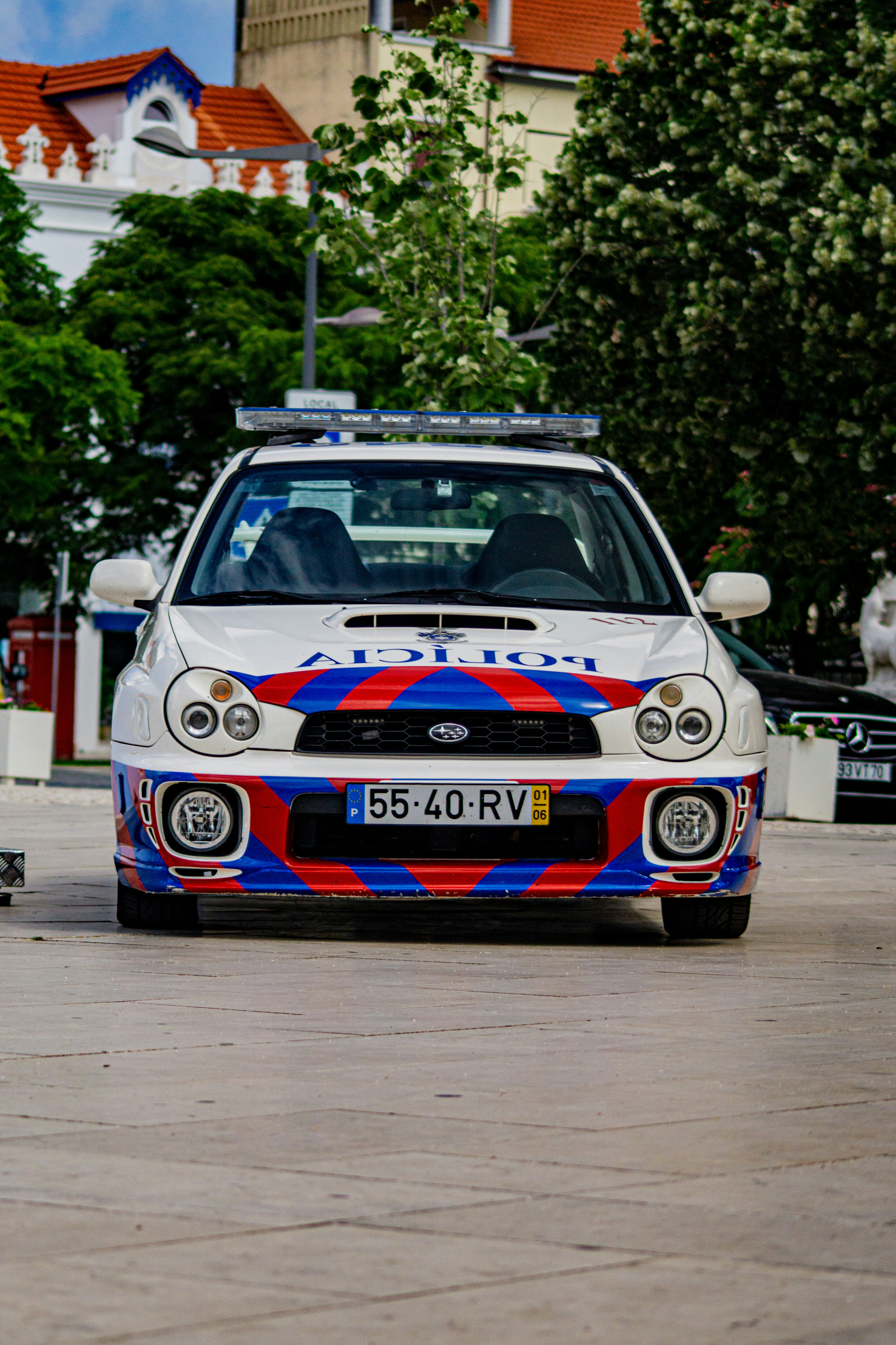 A white car with a red, blue, and white design on it