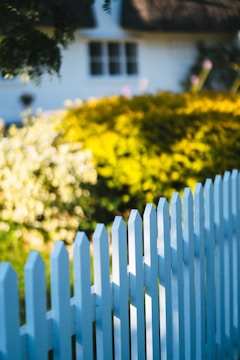 A white picket fence in front of a house