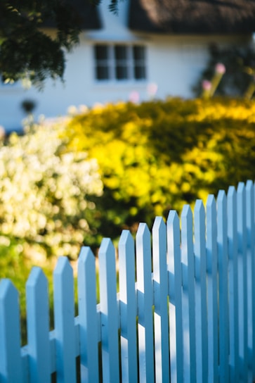 A white picket fence in front of a house