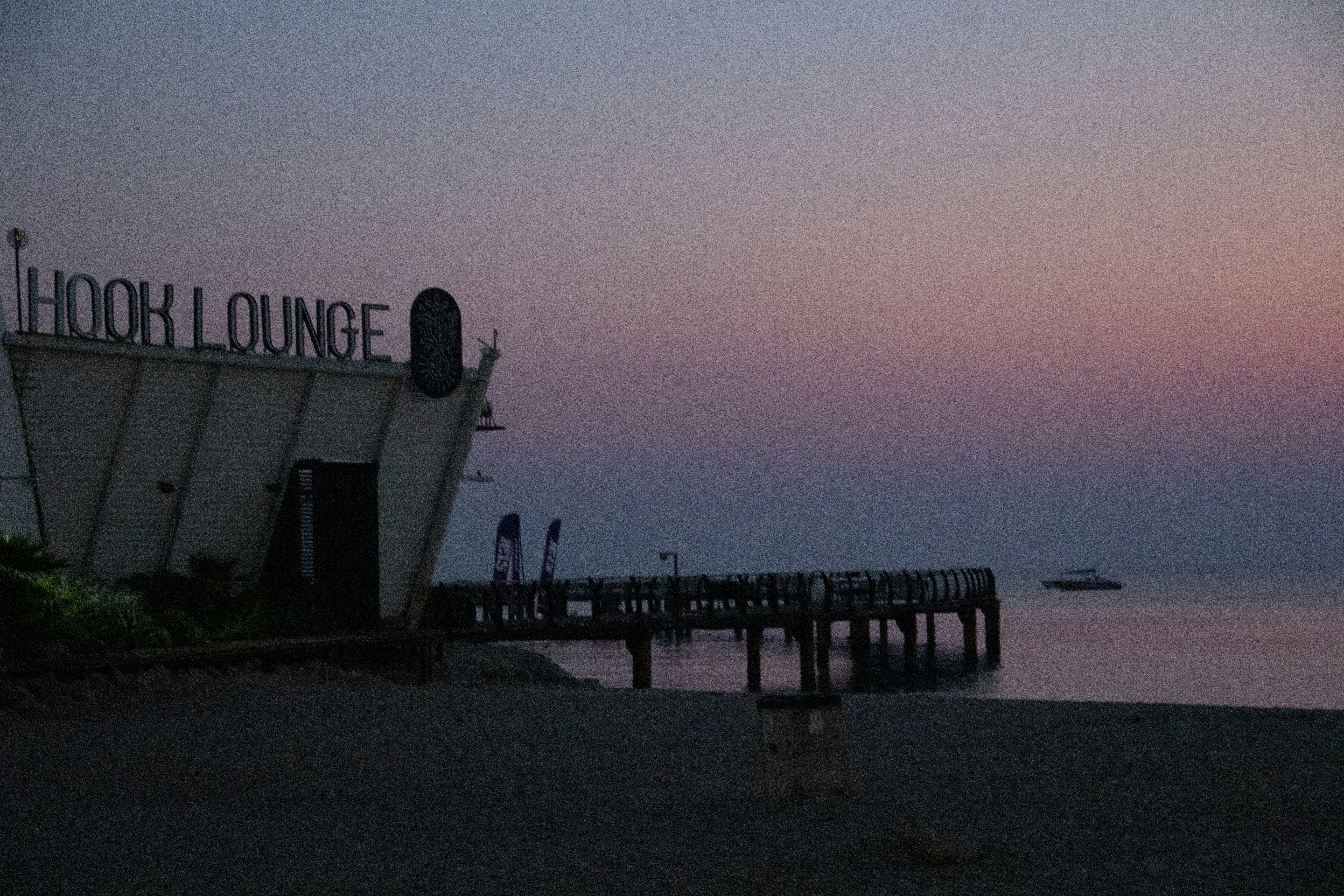 A beach with a pier and a boat in the water, Kish island 🏝️