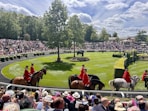 A group of people riding horses on a race track