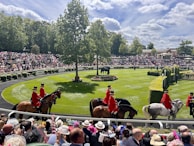 A group of people riding horses on a race track