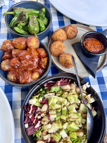 A table topped with bowls of food next to plates of food